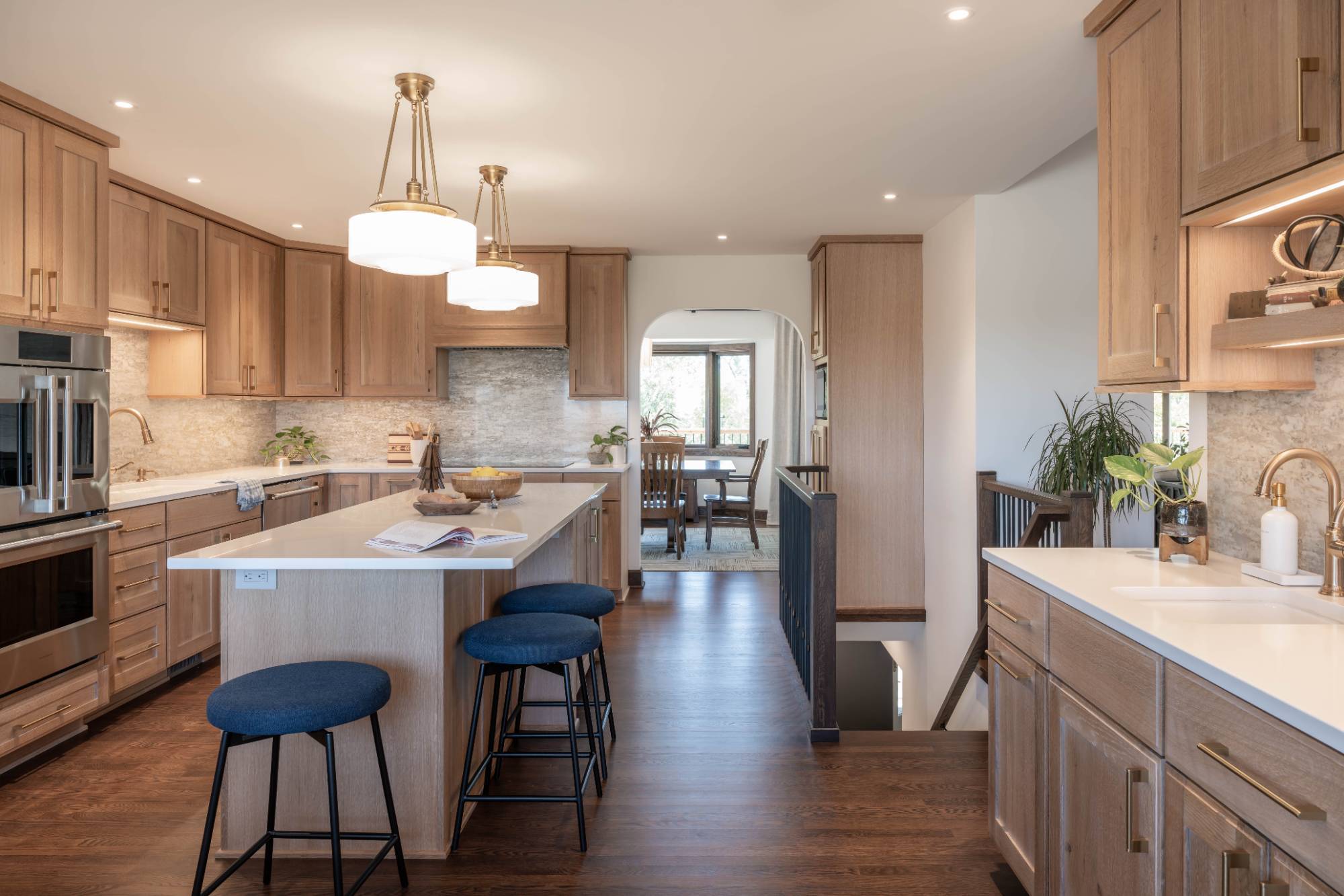 Custom kitchen remodel by HC Remodel & Design in Omaha, NE with white countertops, wood cabinetry, and a large island.-optimized