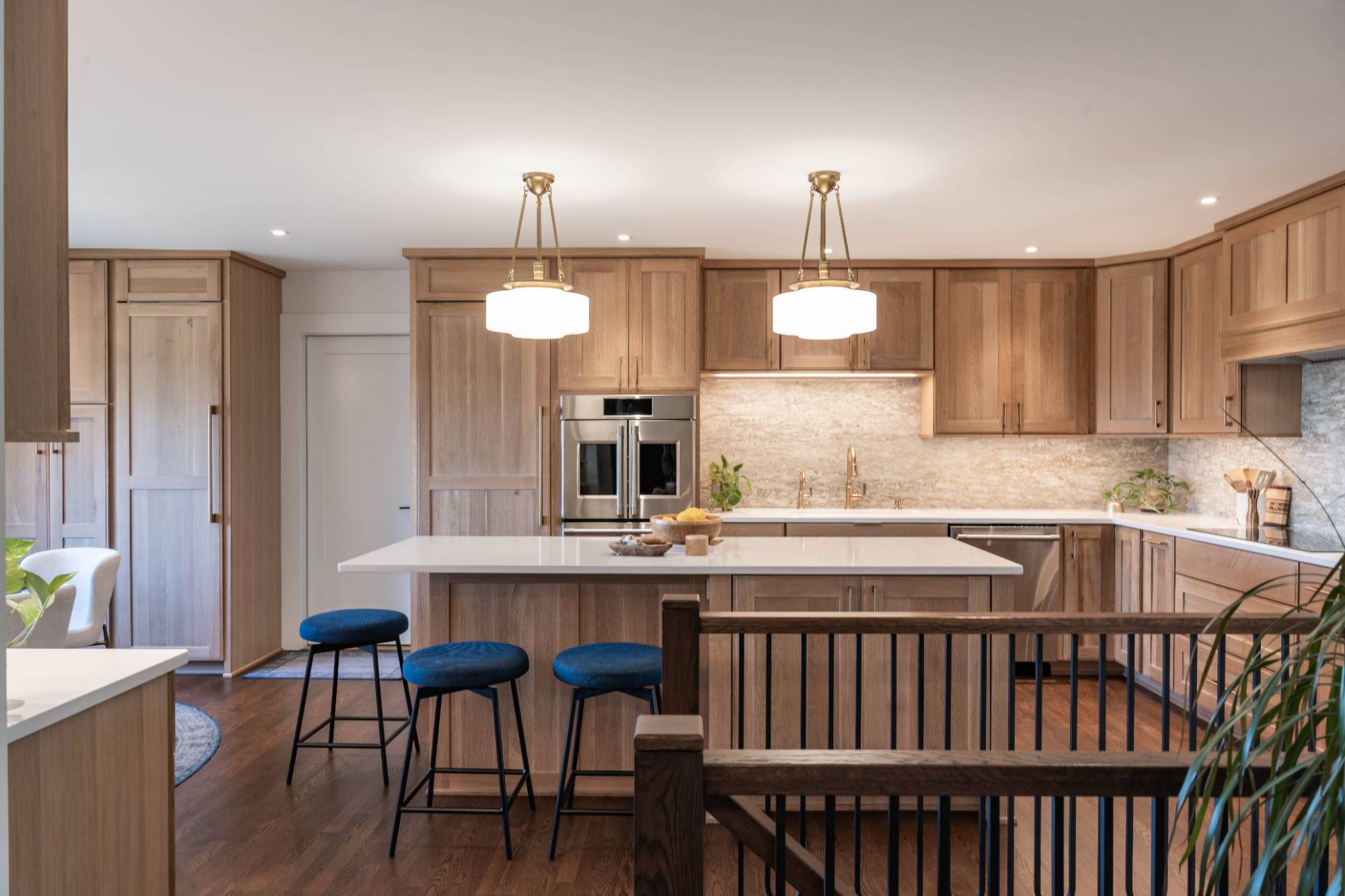 Wide view of a remodeled kitchen with custom cabinetry, oversized island, and warm wood finishes by HC Remodel & Design in Counc-optimized