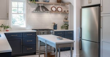 Renovated kitchen with navy cabinets, open shelving, white counters, and stainless appliances in Omaha & Council Bluffs.
