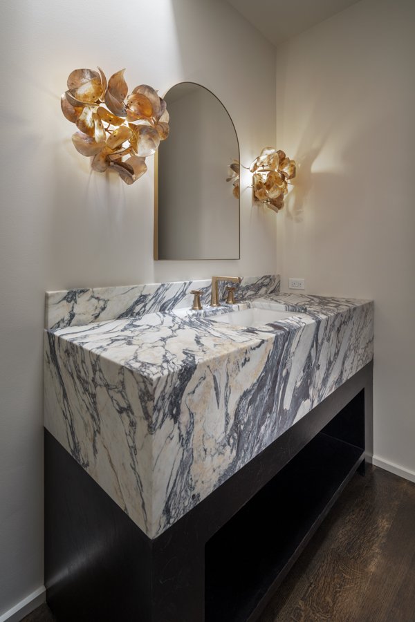 Bathroom remodel by HC Remodel & Design in Omaha, NE featuring a waterfall marble vanity with integrated sink, arched mirror, an-optimized