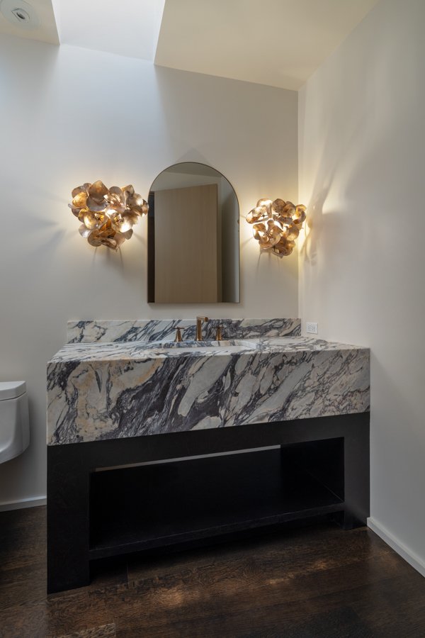 Luxury bathroom remodel by HC Remodel & Design in Omaha, NE featuring a dramatic marble waterfall vanity, arched mirror, and des-optimized