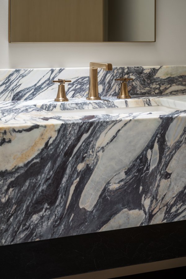 Luxury bathroom remodel in Omaha, NE by HC Remodel & Design highlighting custom marble craftsmanship and modern sink hardware.-optimized