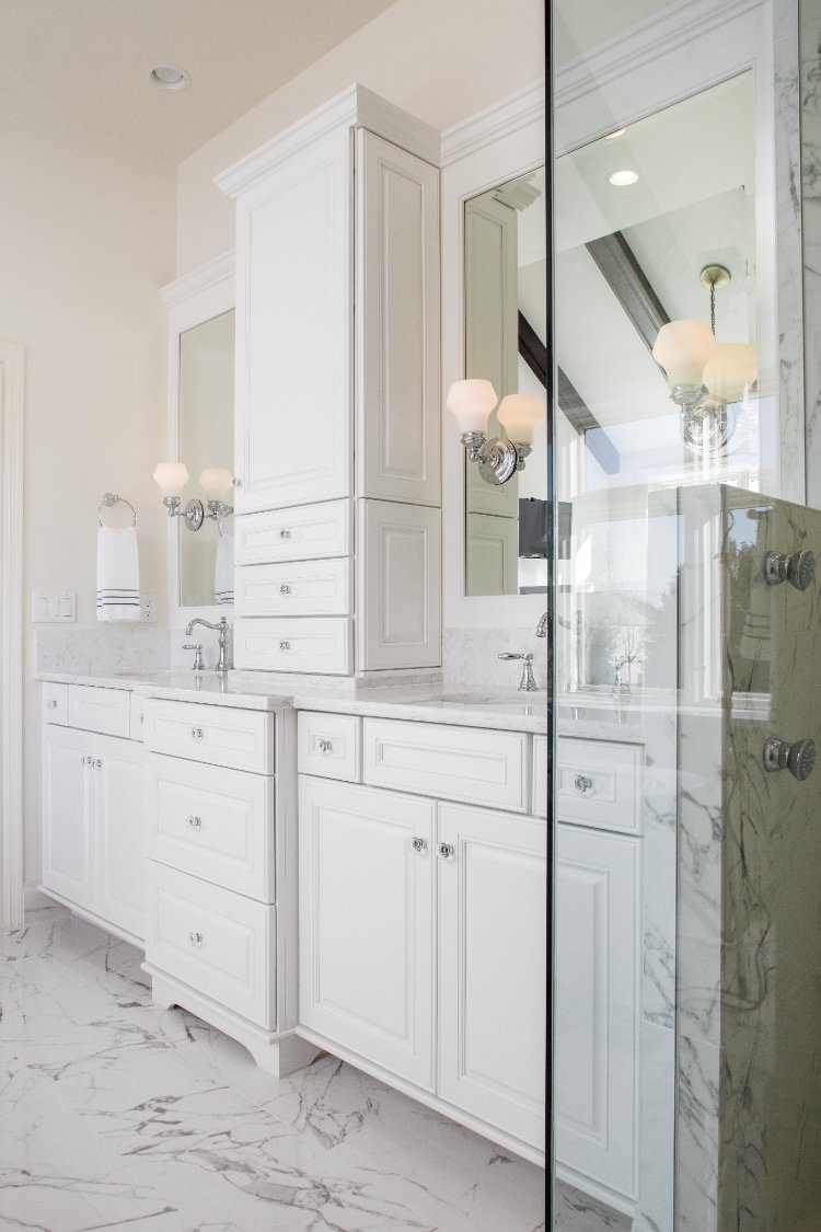Master bathroom remodel by HC Remodel & Design in Omaha, NE featuring a custom white vanity with marble countertops beside a gla-optimized