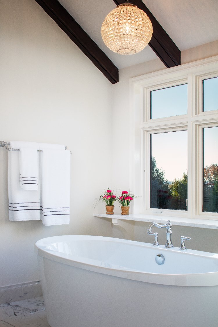 Master bathroom remodel by HC Remodel & Design in Omaha, NE featuring a freestanding soaking tub beneath oversized windows with -optimized
