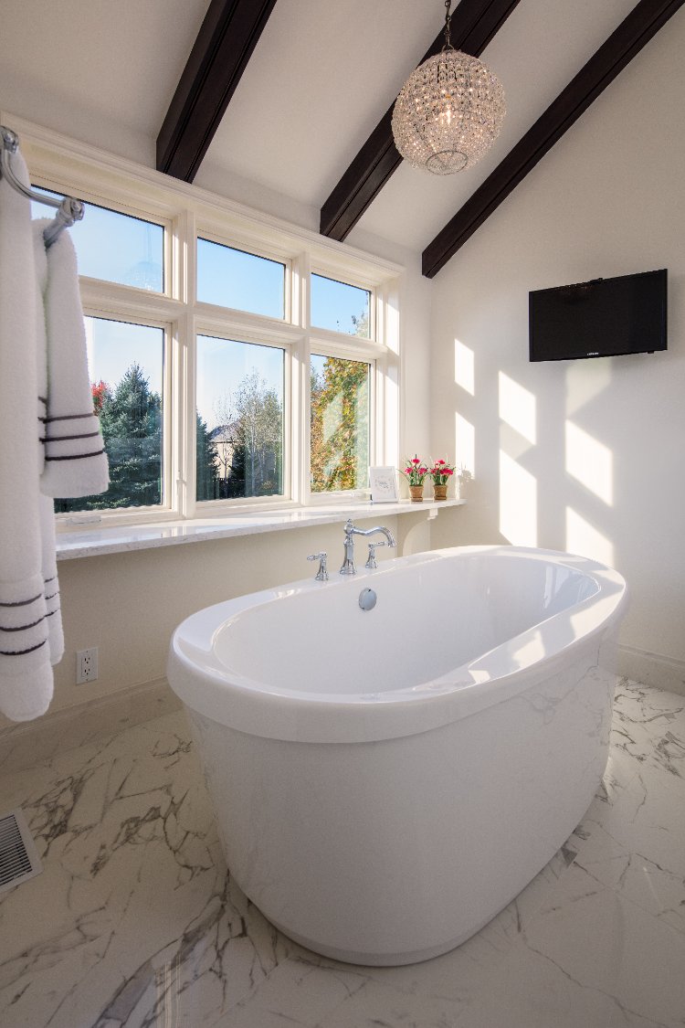 Master bathroom remodel by HC Remodel & Design in Omaha, NE featuring a freestanding soaking tub beneath vaulted ceilings with e-optimized