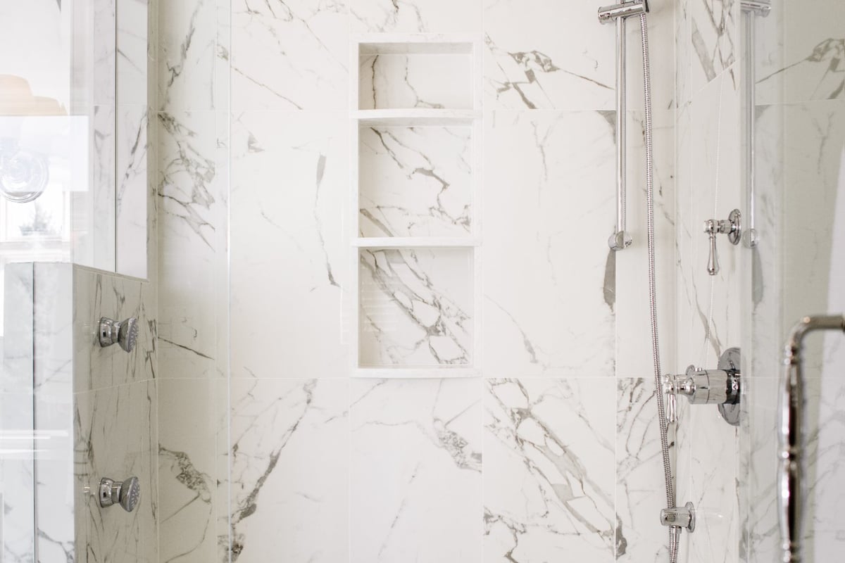 Master bathroom remodel by HC Remodel & Design in Omaha, NE featuring a marble walk-in shower with built-in storage niches and p-optimized