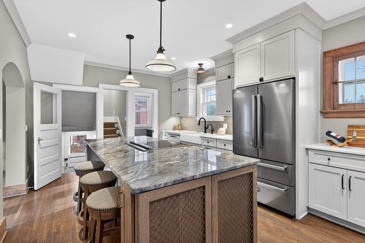 kitchen-island-with-stone-countertop-and-bar-stools-galley-view-omaha-ne-optimized