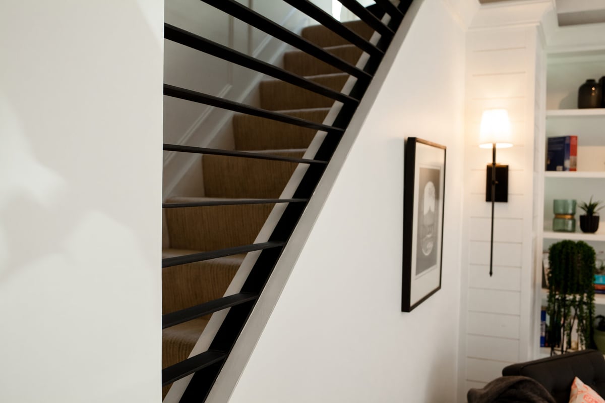 staircase-with-black-railing-and-wall-sconces-omaha-ne-optimized