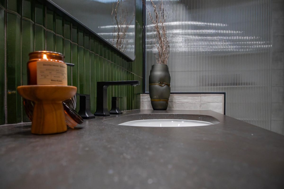 HC Remodel & Design bathroom vanity in Omaha, NE with dark concrete countertop, matte black fixtures, glossy green tile backspla-optimized