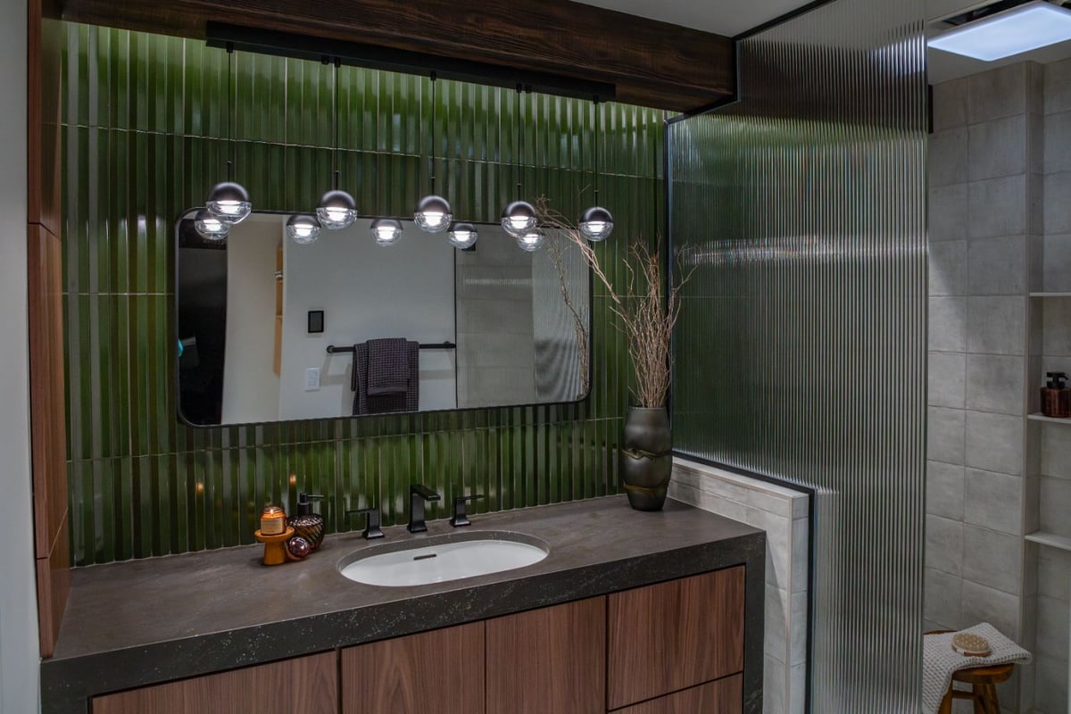 Modern bathroom remodel by HC Remodel & Design in Omaha, NE featuring a walnut vanity, green textured tile, and fluted glass sho-optimized