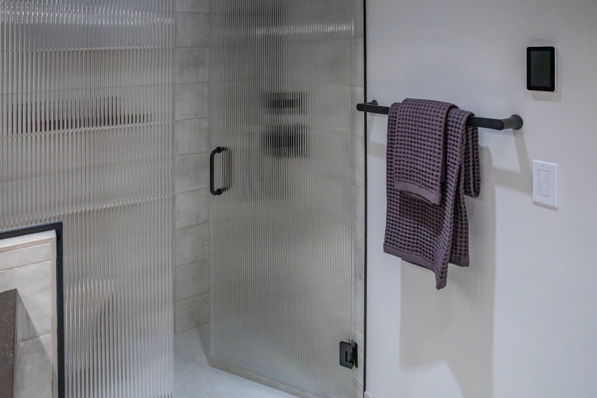 Modern fluted glass shower door with matte black hardware by HC Remodel & Design in Omaha, NE bathroom remodel.-optimized