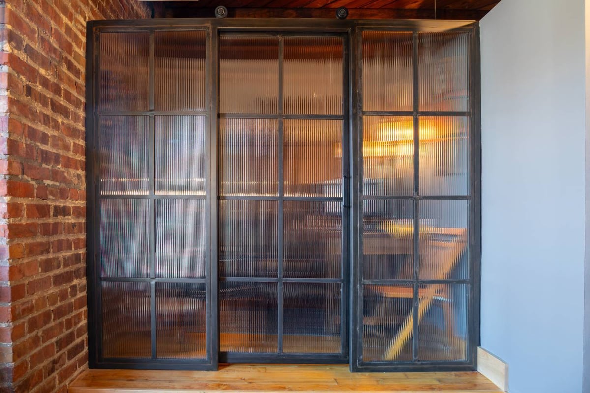 Full view of a custom steel and fluted glass office partition installed by HC Remodel & Design in Omaha, NE.-optimized
