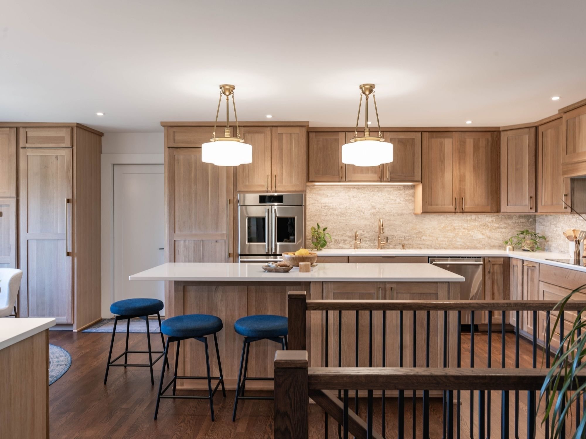 Bright kitchen with natural wood cabinetry, white island, and pendant lighting in Omaha & Council Bluffs.