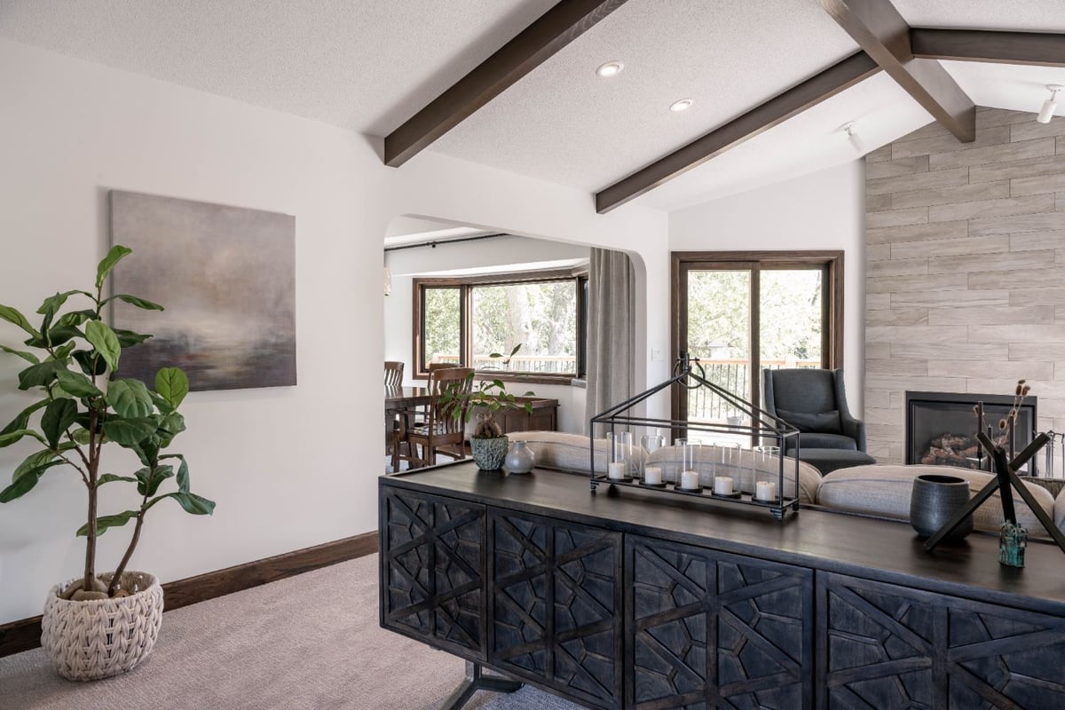 Contemporary living room remodel by HC Remodel & Design in Omaha, NE featuring exposed ceiling beams, a modern fireplace, and an-optimized