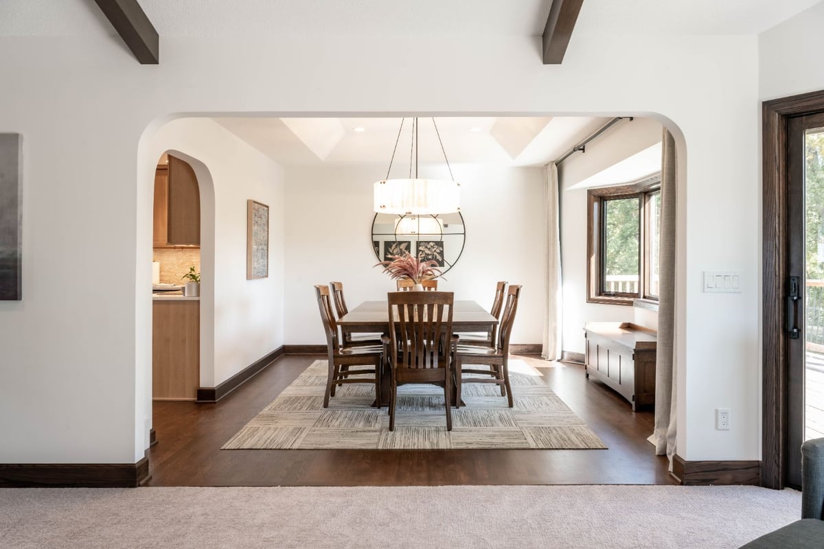 Dining room remodel by HC Remodel & Design in Omaha, NE with a modern light fixture, hardwood floors, and large windows.-optimized