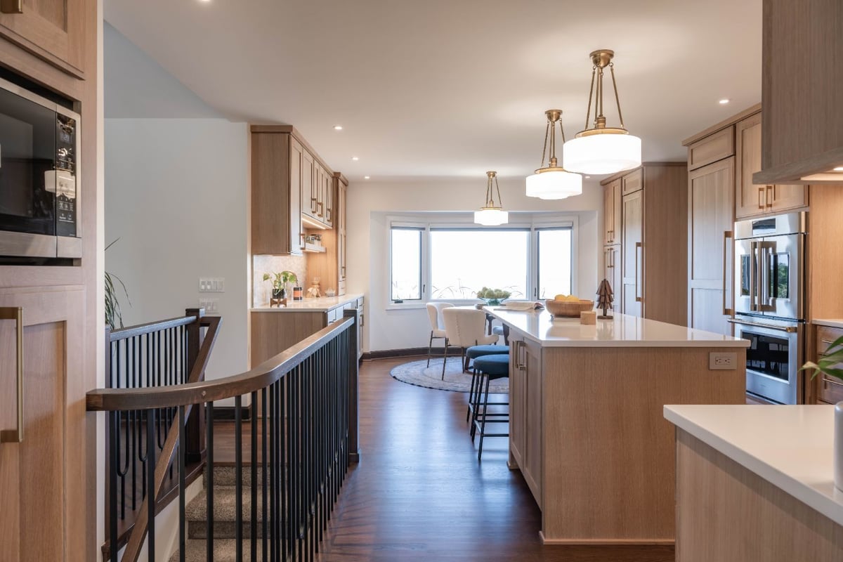 Kitchen remodel by HC Remodel & Design in Omaha, NE featuring light wood cabinetry, a large island, and quartz countertops.-optimized