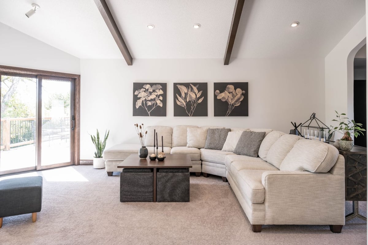 Living room remodel by HC Remodel & Design in Omaha, NE featuring vaulted ceilings, exposed beams, and a spacious sectional.-optimized
