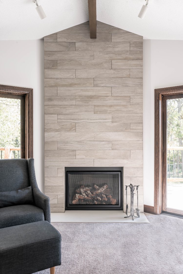 Modern fireplace remodel by HC Remodel & Design in Omaha, NE with a floor-to-ceiling tile surround and vaulted ceiling.-optimized