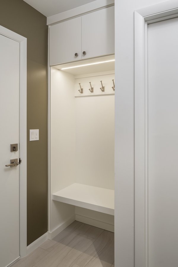 HC Remodel & Design laundry room remodel in Omaha, NE featuring a custom mudroom bench with overhead cabinetry and built-in coat-optimized