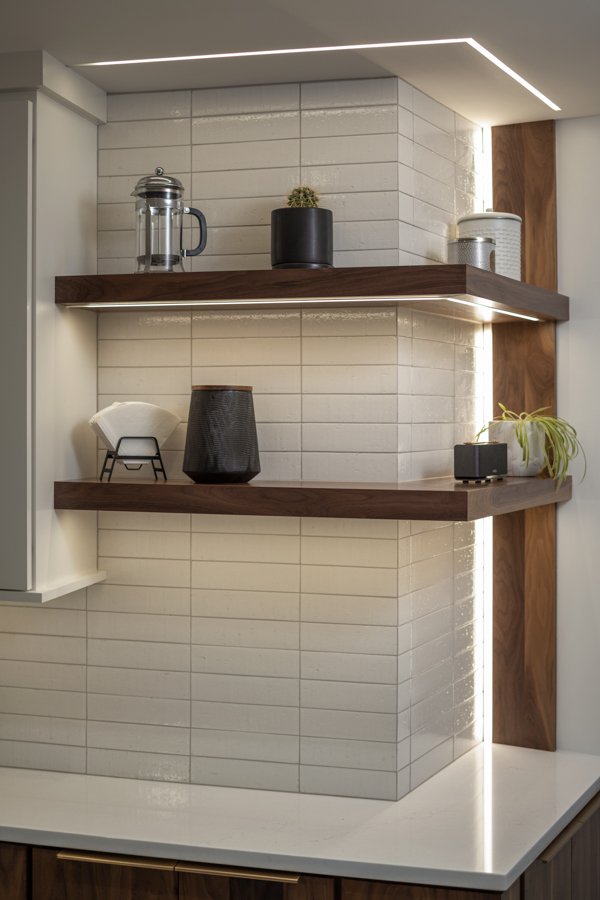 Modern kitchen shelving in Omaha, NE by HC Remodel & Design showcasing custom walnut shelves and illuminated display storage.-optimized