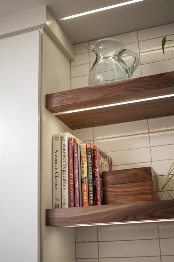 Modern open shelving by HC Remodel & Design in Omaha, NE with integrated LED lighting and custom walnut shelves.-optimized