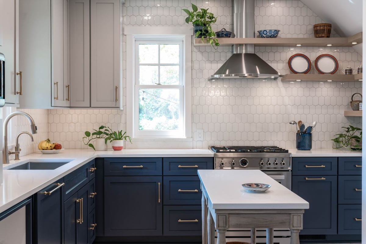 Kitchen remodel by HC Remodel & Design in Omaha, NE highlighting floating wood shelves, a stainless steel hood, and custom blue -optimized