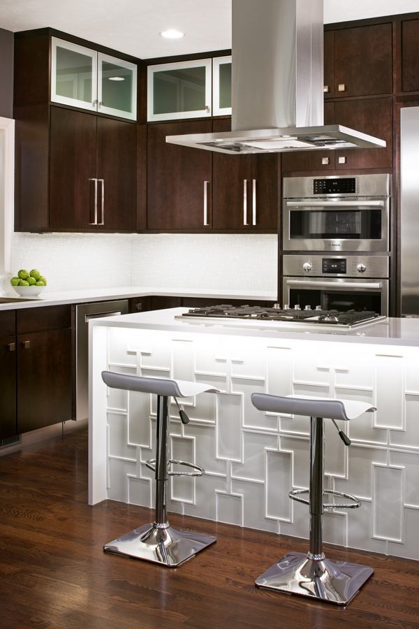 Modern kitchen remodel by HC Remodel & Design in Omaha, NE featuring a custom waterfall island, geometric paneling, and dark woo-optimized