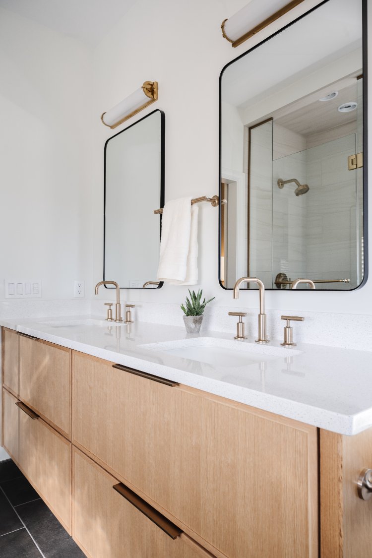 Contemporary double sink vanity featuring white oak cabinetry and brushed brass fixtures by HC Remodel & Design in Papillion, NE-optimized