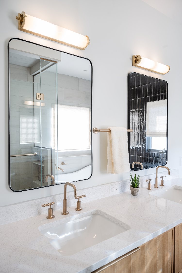 Dual vanity with black framed mirrors and glass shower in a primary bathroom remodel by HC Remodel & Design in Papillion, NE.-optimized