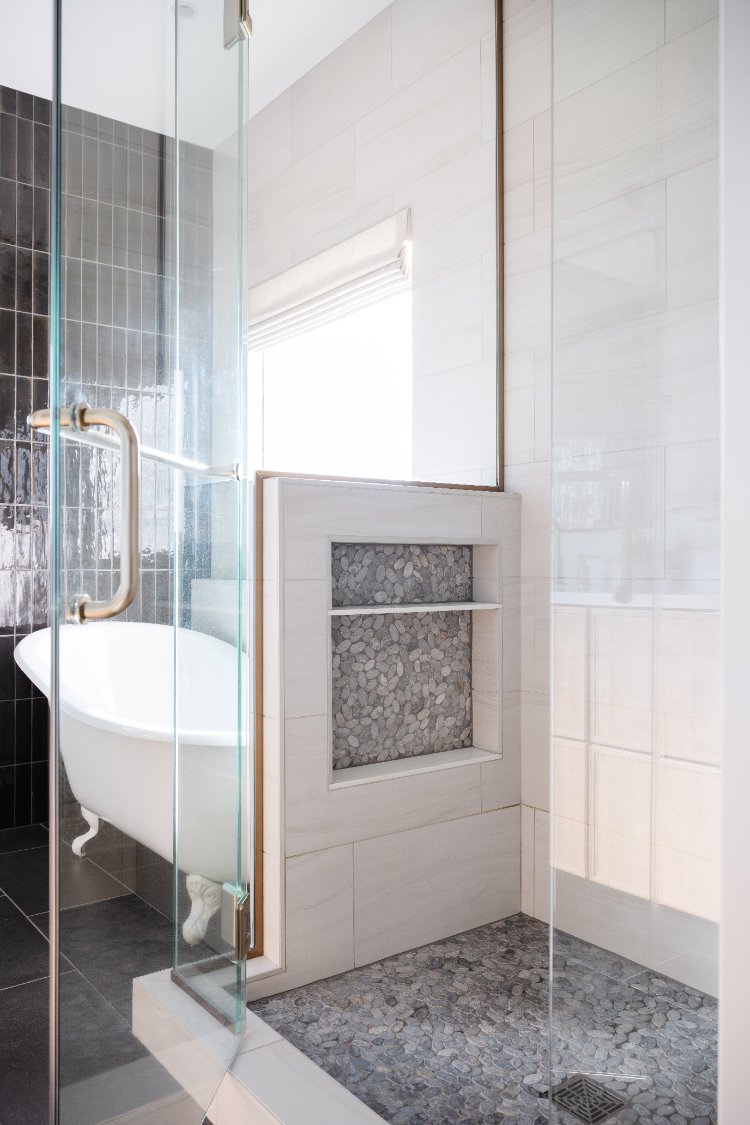 Glass walk-in shower with pebble tile niche in a primary bathroom remodel by HC Remodel & Design in Papillion, NE.-optimized