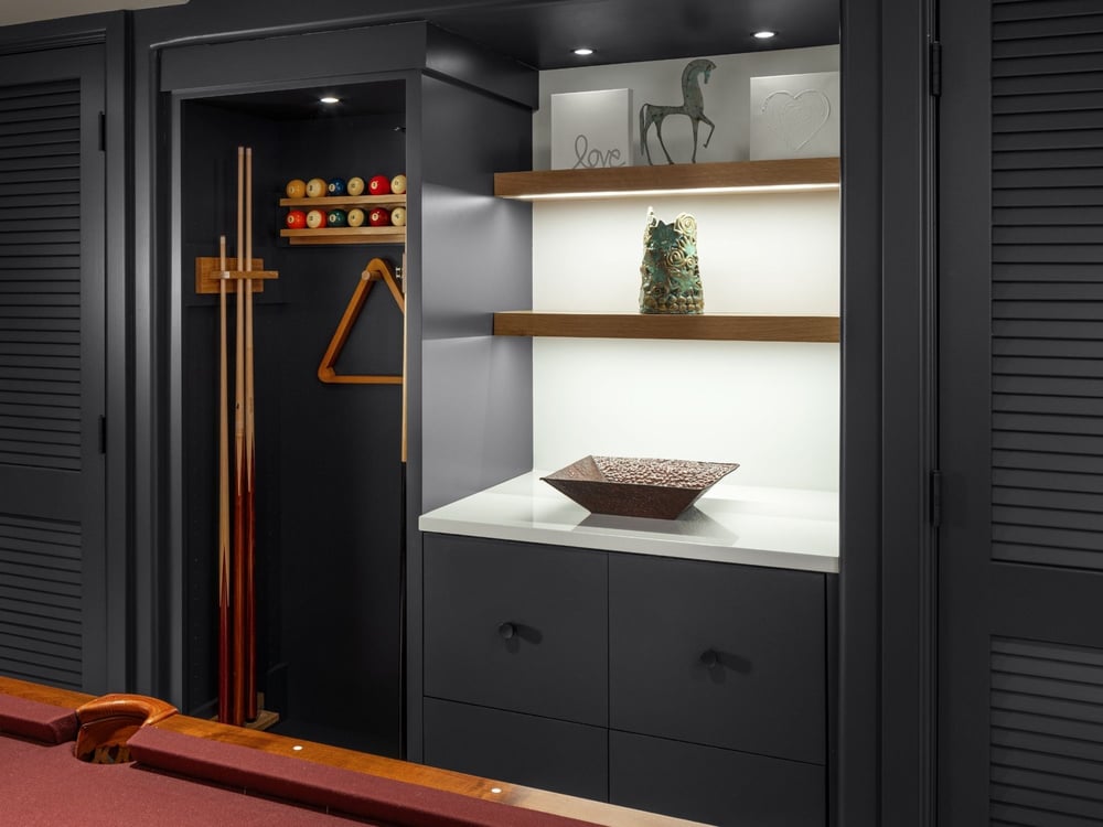 Finished basement game room with built-in shelving, cabinetry, and pool cue storage in Omaha & Council Bluffs - optimized.
