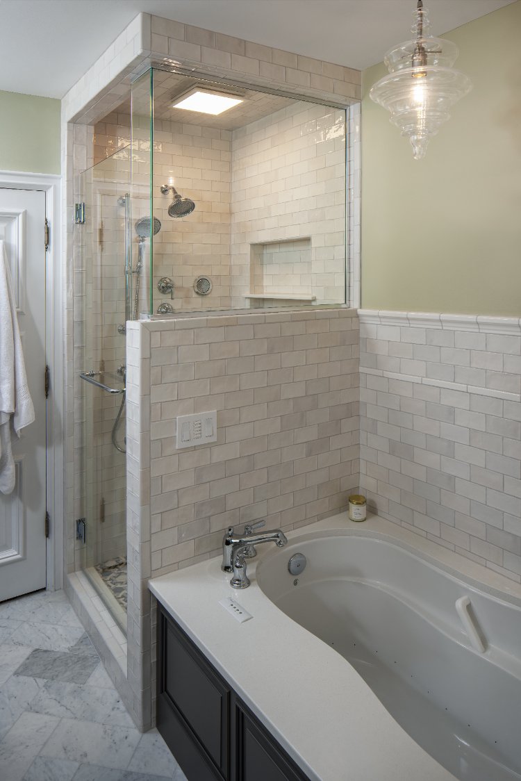 Primary bathroom remodel by HC Remodel & Design in Omaha, NE featuring a freestanding soaking tub beside a glass-enclosed tiled -optimized