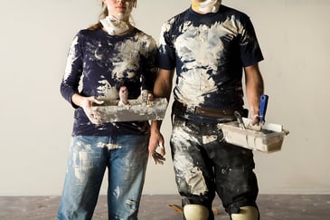 Stock image of two people covered in paint from their remodel