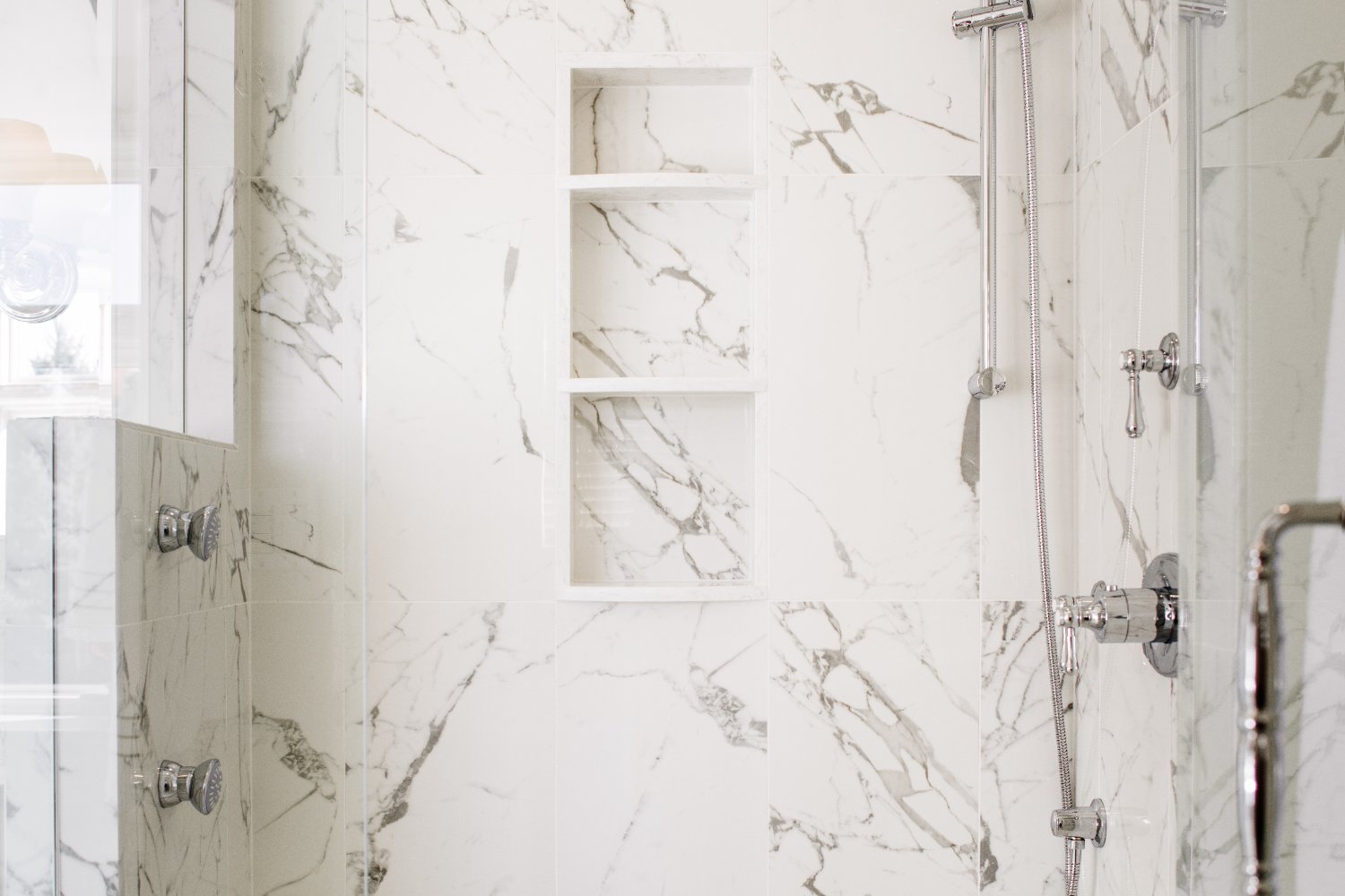 Master bathroom remodel by HC Remodel & Design in Omaha, NE featuring a marble walk-in shower with built-in storage niches and p-optimized