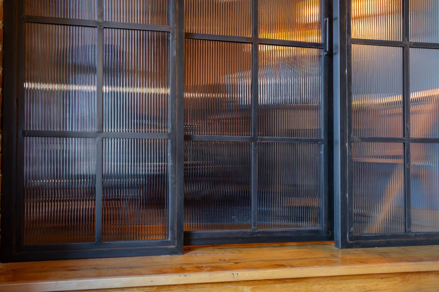Industrial office remodel showcasing custom fluted glass sliding doors by HC Remodel & Design in Omaha, NE.-optimized