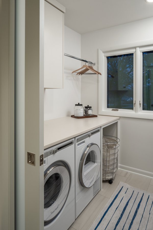 HC Remodel & Design laundry room remodel in Omaha, NE featuring custom cabinetry, a countertop workspace, and front-loading wash-optimized