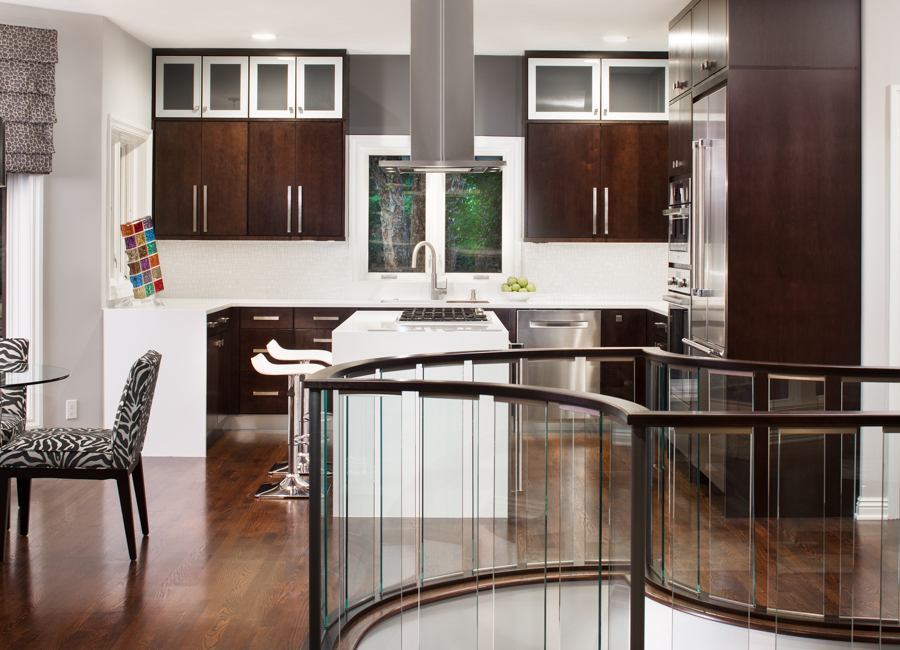 Open-concept kitchen remodel by HC Remodel & Design in Omaha, NE featuring dark wood cabinetry, a custom island, and glass stair-optimized