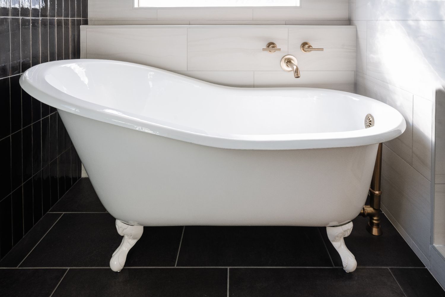 Freestanding soaking tub with brushed brass tub filler in a primary bathroom remodel by HC Remodel & Design in Papillion, NE.