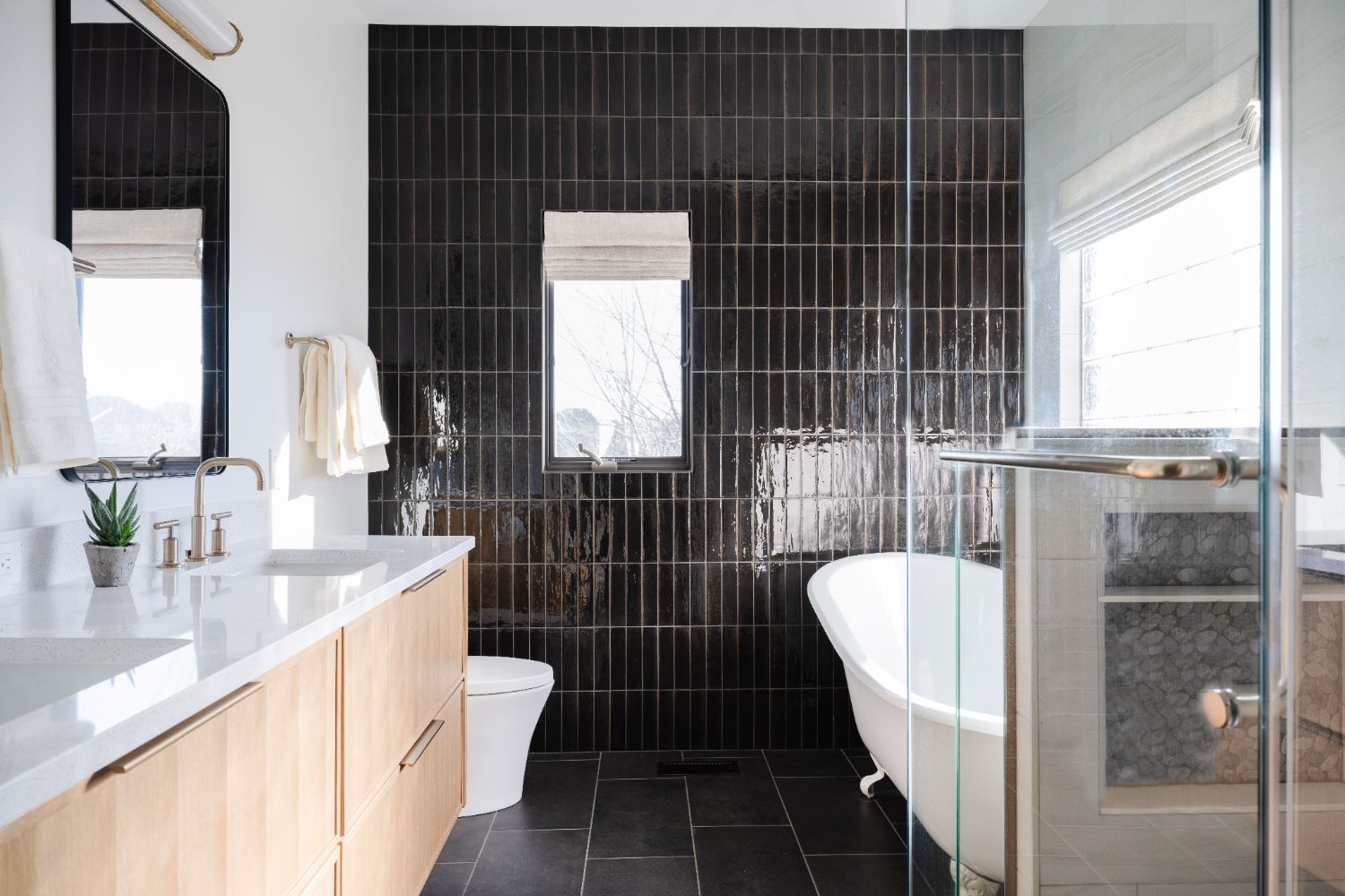 Modern primary bathroom remodel by HC Remodel & Design in Papillion, NE featuring a freestanding soaking tub, black accent tile -optimized