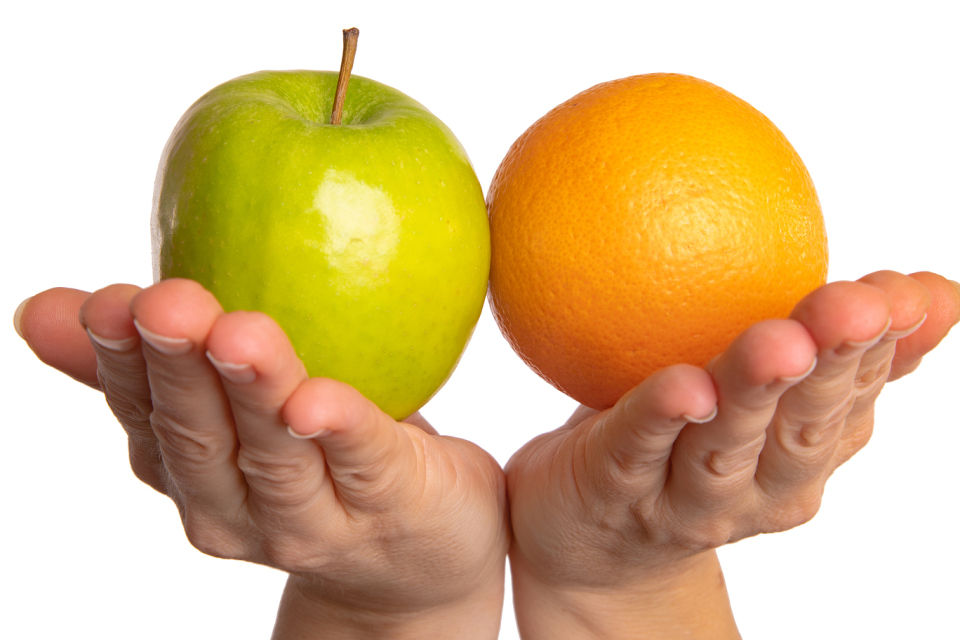 Image of two hands holding an apple and an orange